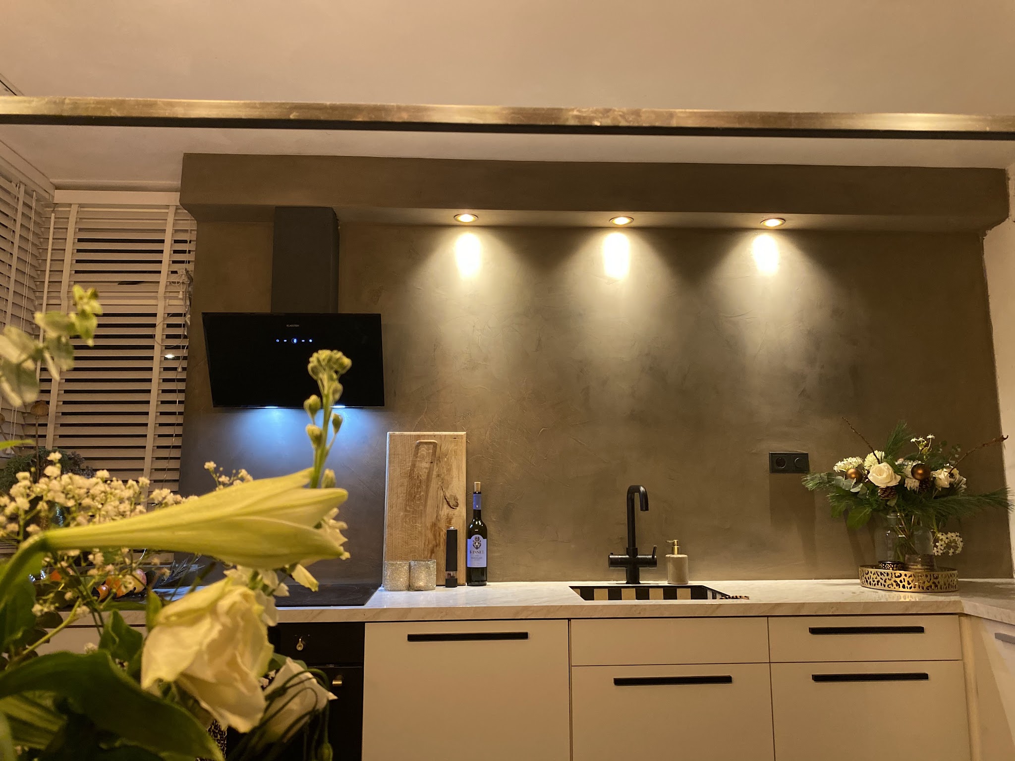 Keuken met metallic stucwand boven het werkblad en inbouwspots
