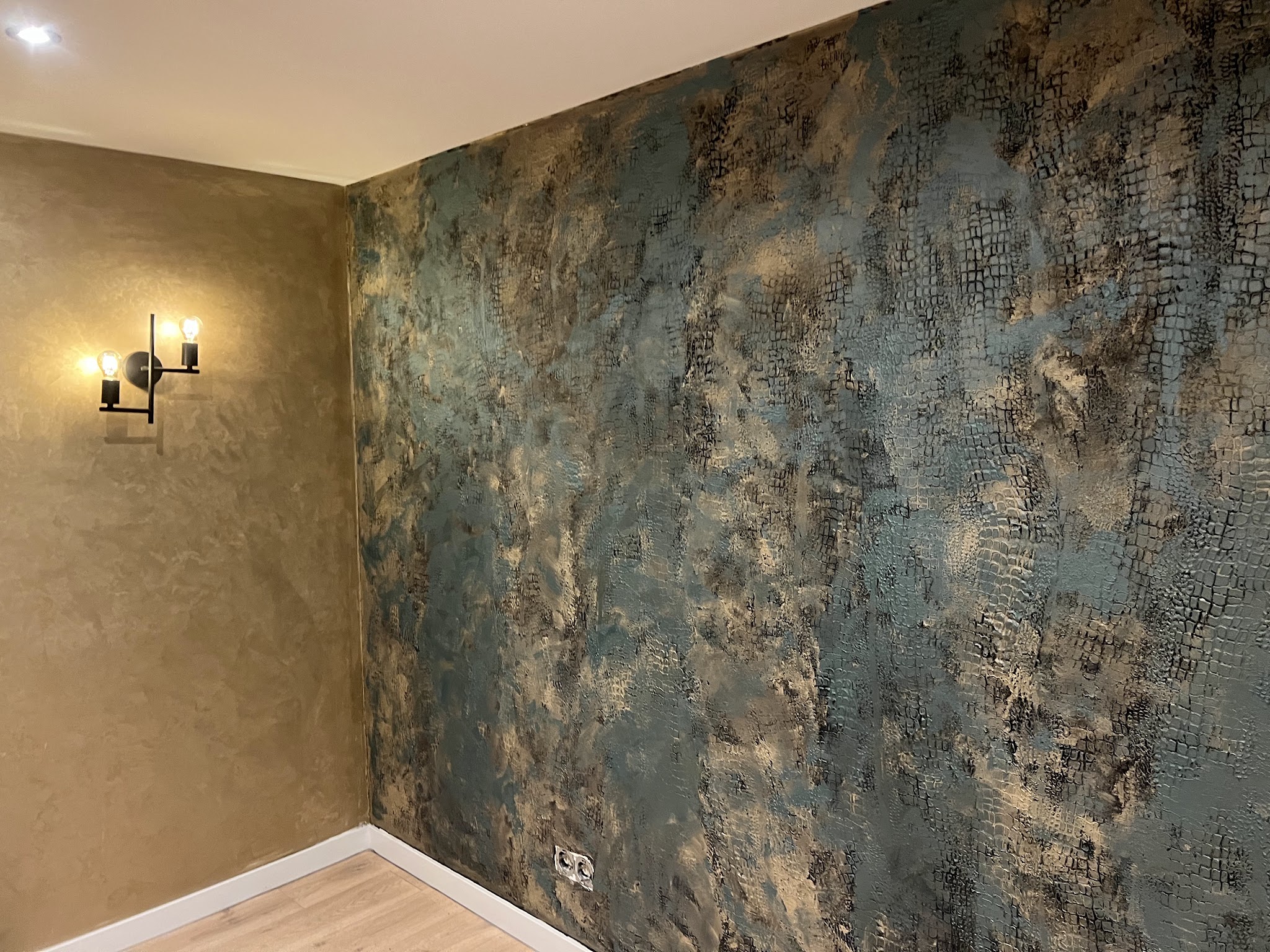 Designwand in blauw en goud met wandlampen
