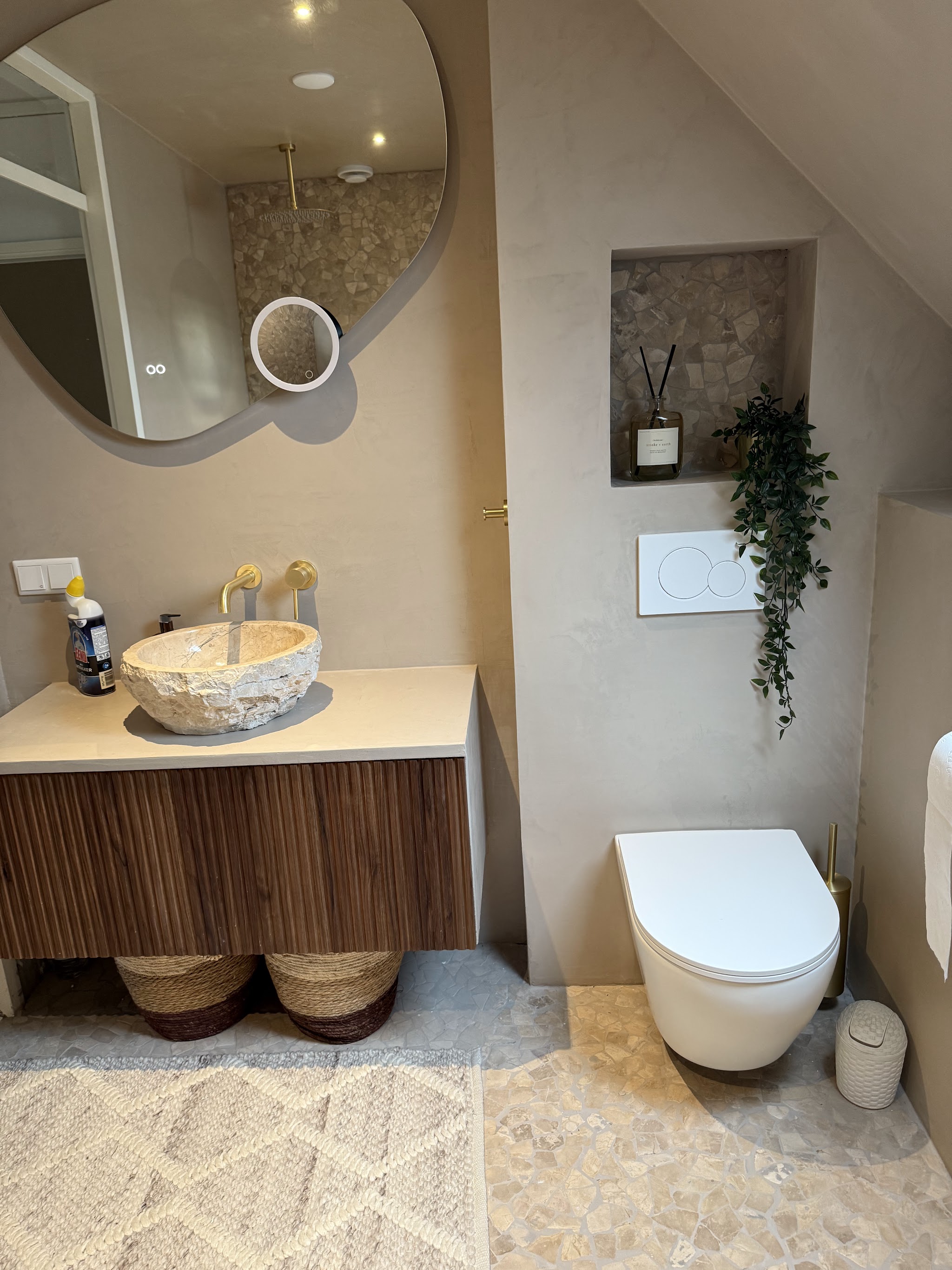Badkamer met beige stucwerk en een natuurstenen waskom